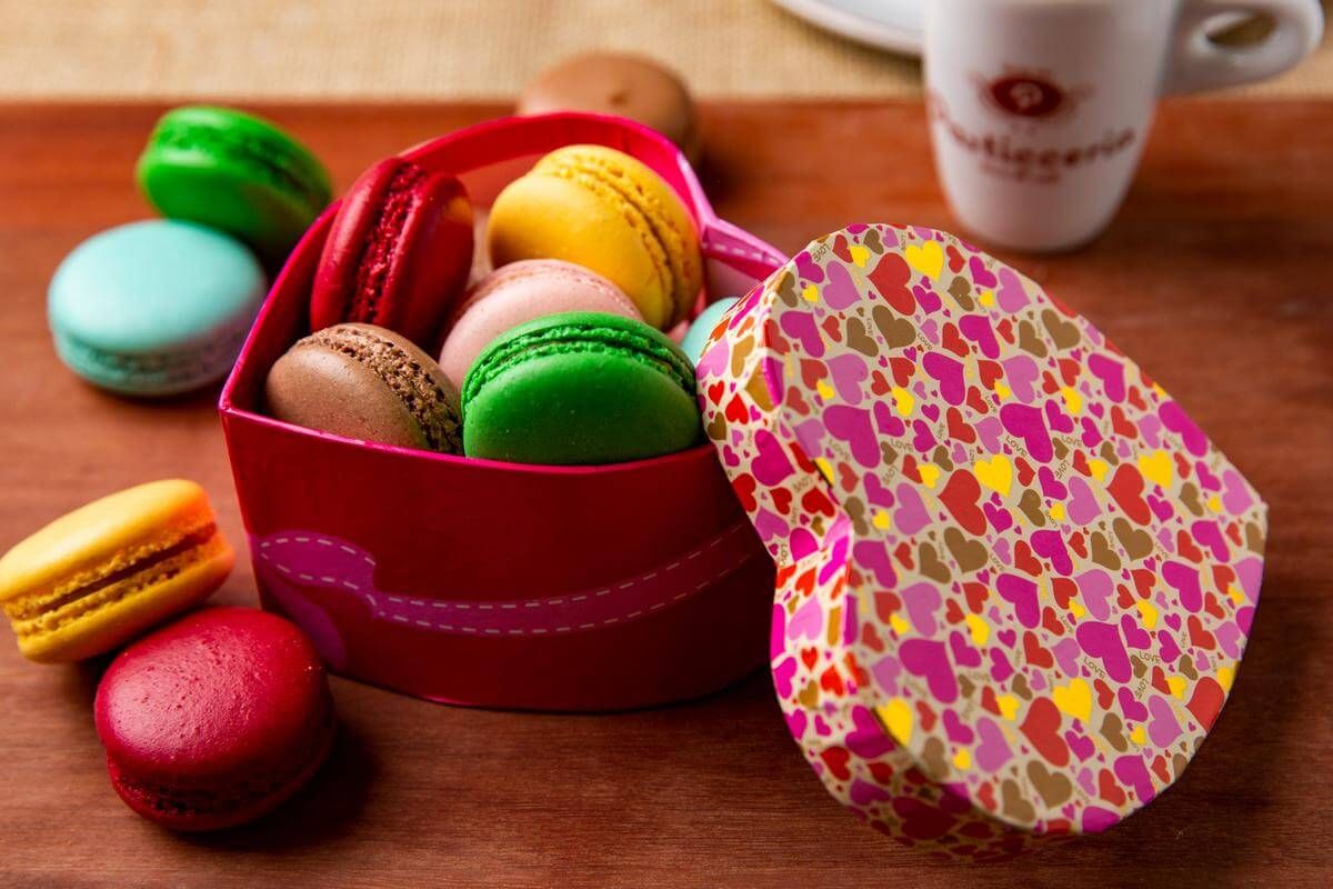 Fotografia de macarons coloridos em caixa de coração para confeitaria